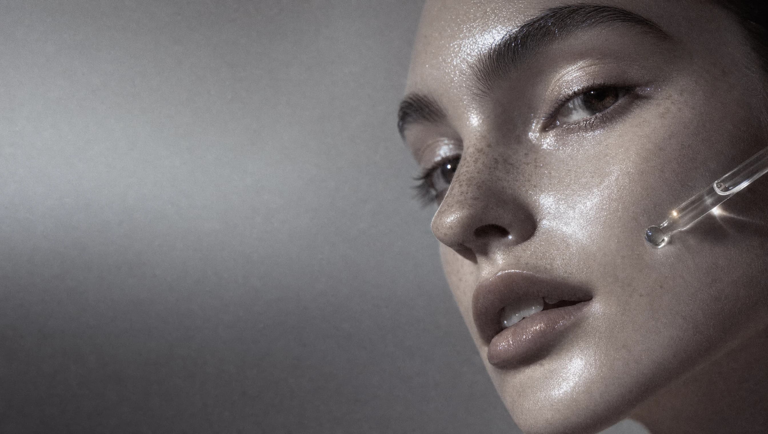 Editorial macro portrait and glass dropper representing skin and barrier research